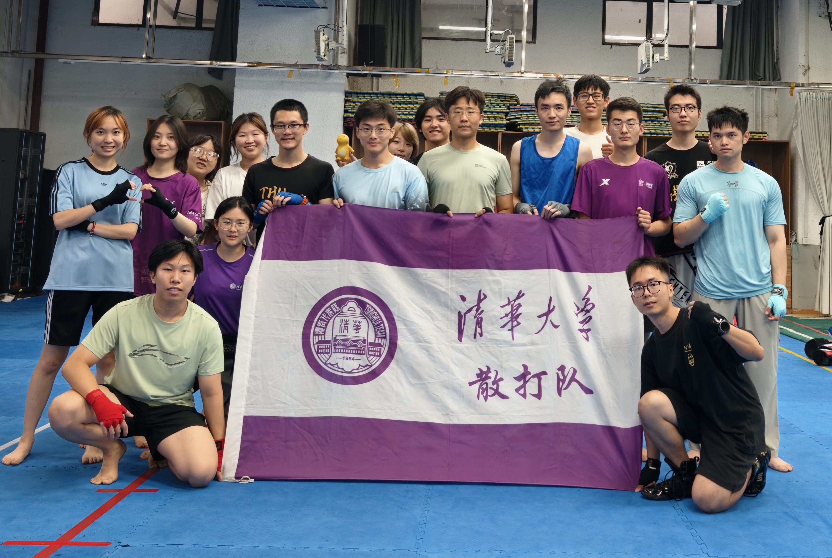 The Tsinghua University Sanda team together behind the team flag